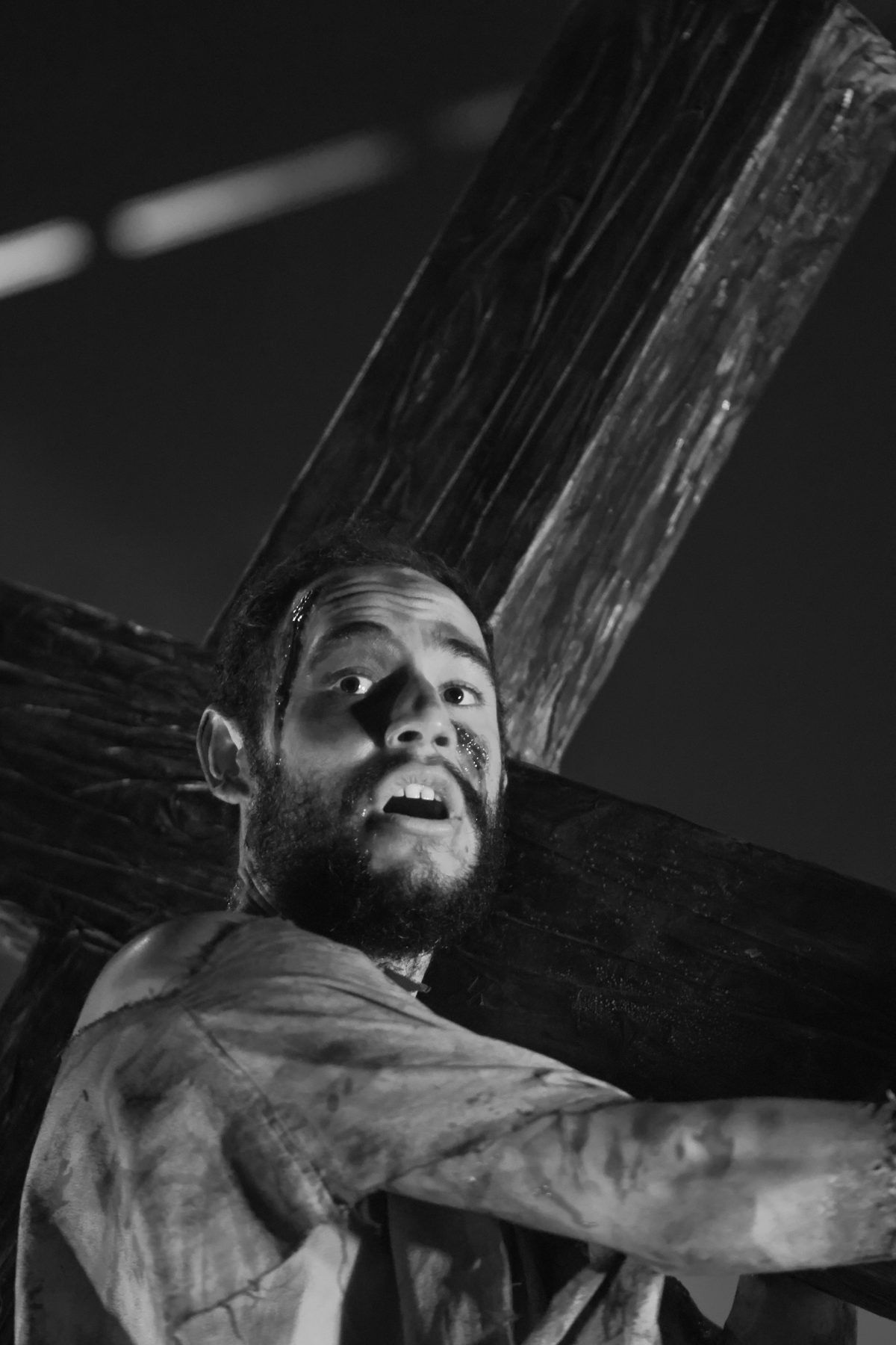 Ator carregando uma cruz de madeira, retrato em preto e branco